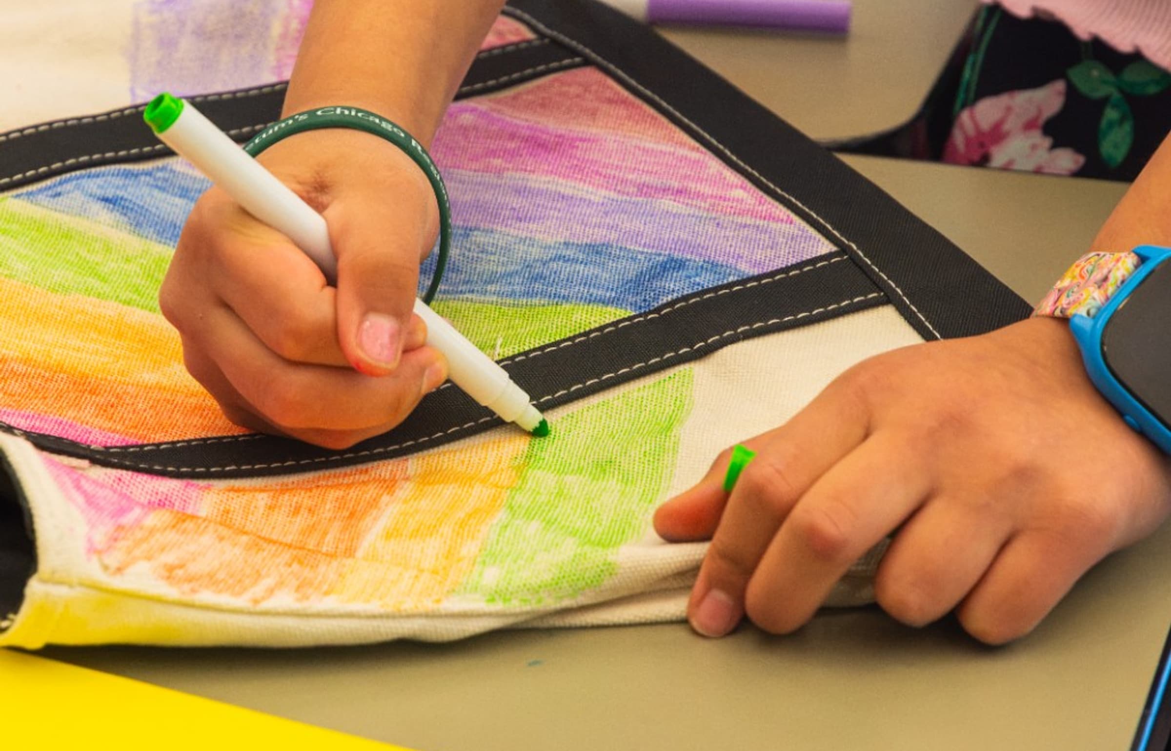 EcoRise student decorating a canvas tote bag with colorful markers