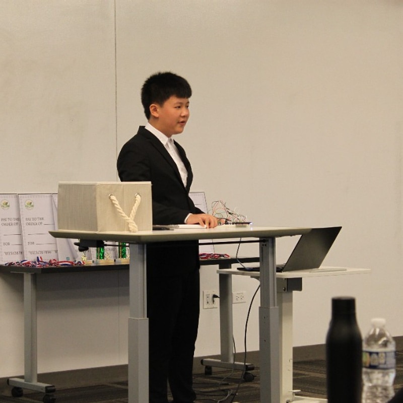 Student presenting an innovation prototype with a breadboard