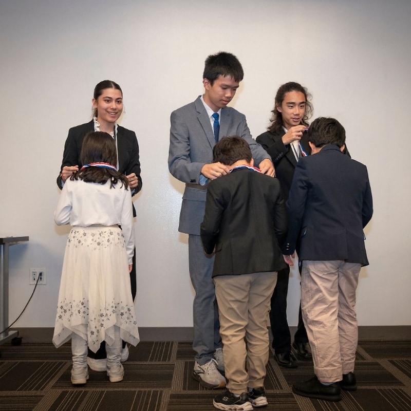 Mentors placing medals on three Green Dream competitors