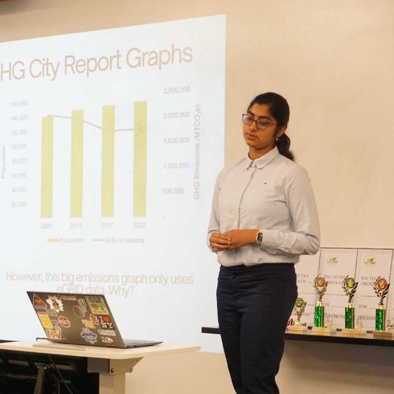 Student presenting Naperville greenhouse gas graphs at the podium