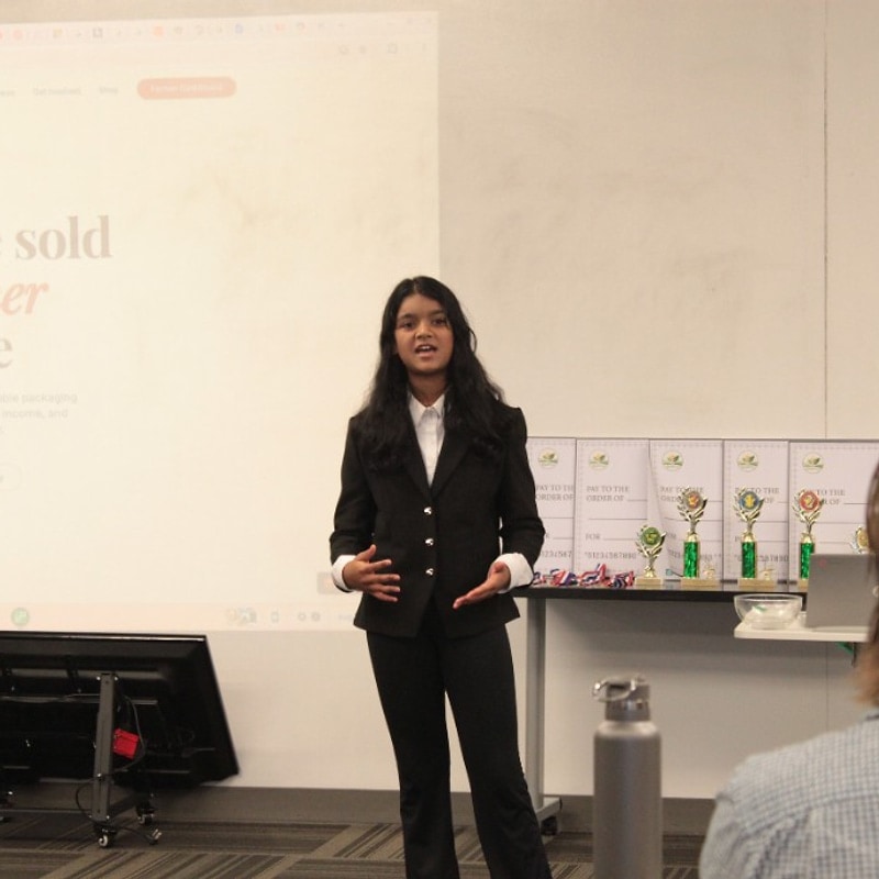 Student in a blazer presenting a farmer packaging project slide