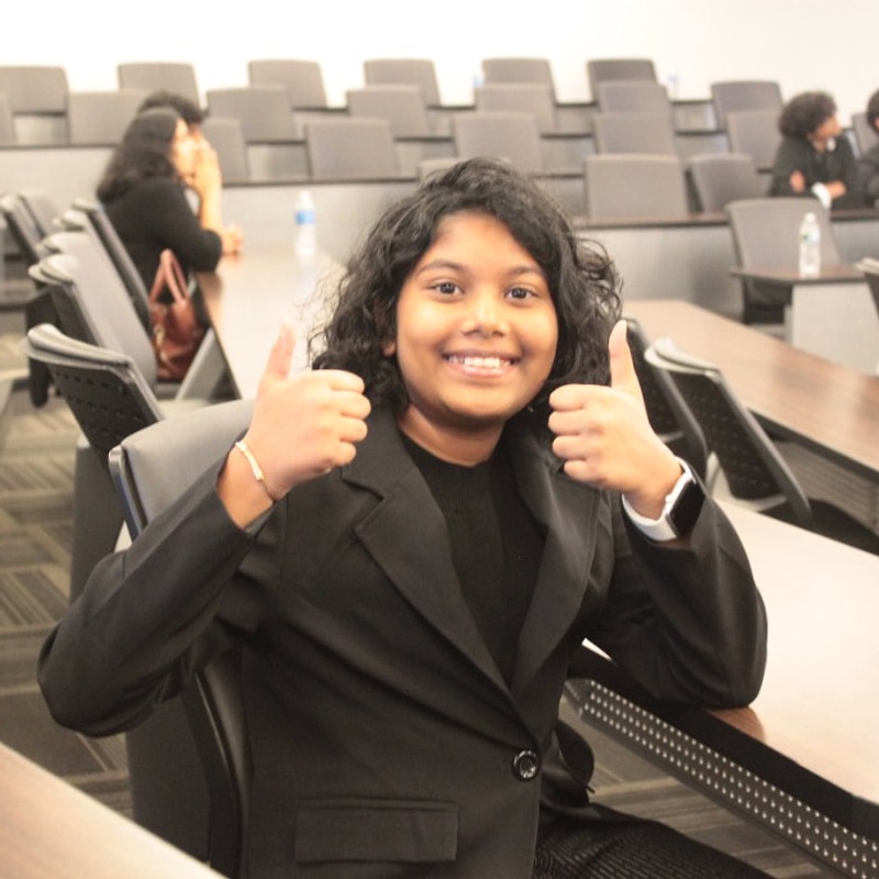 Young woman giving a thumbs up in the lecture hall