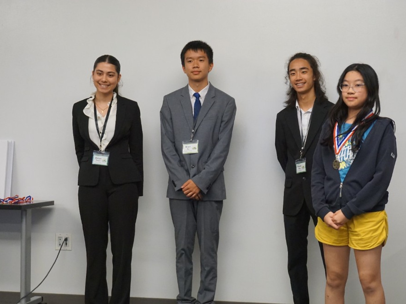 Anna Wu with a medal for LitterLess tenth place, with mentors standing beside her