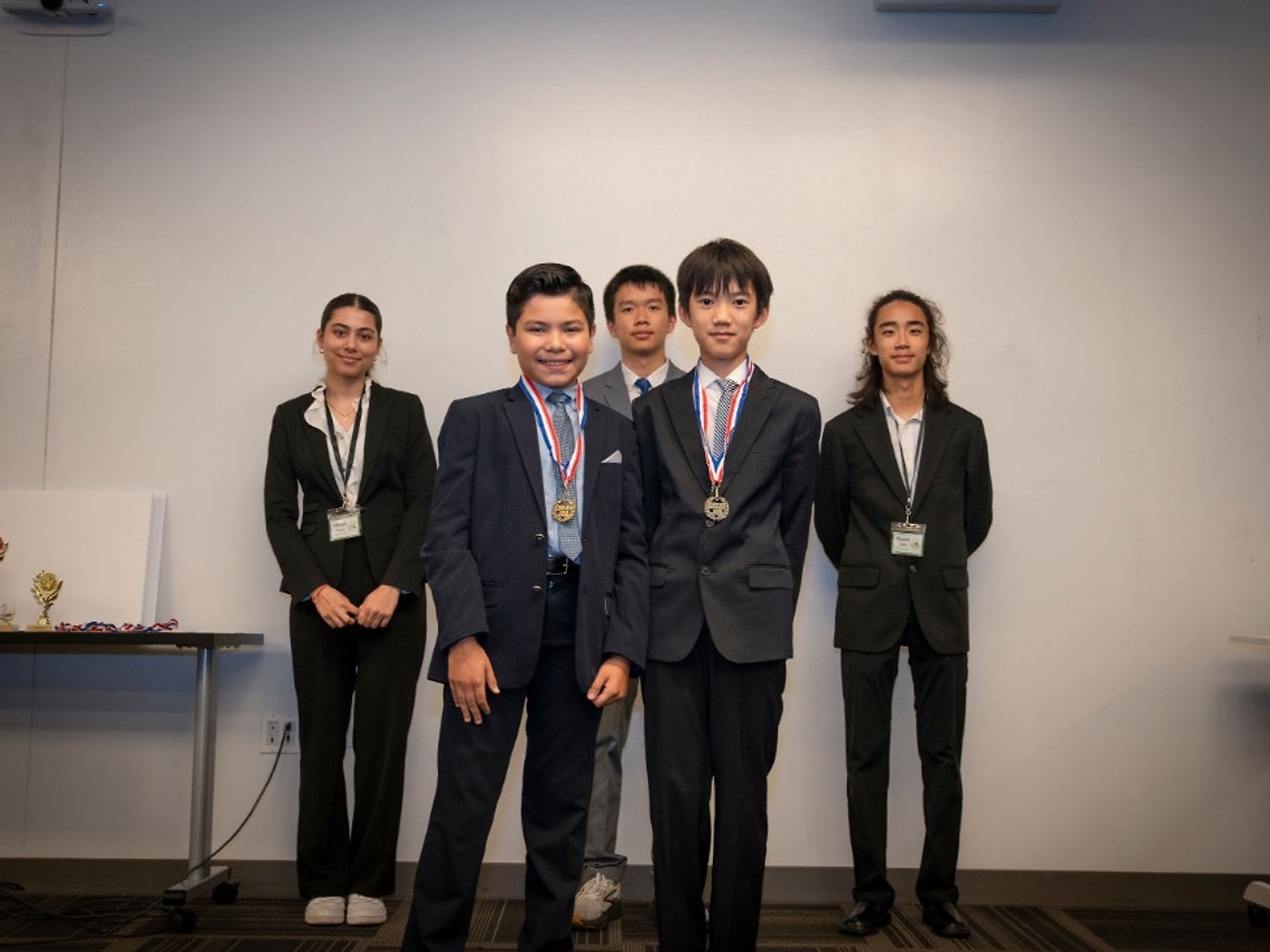 Vincent Zhang and Roberto Davila with medals for Blue Rover ninth place, with mentors standing behind
