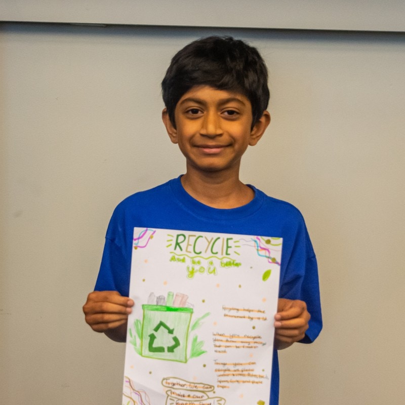 EcoRise camper holding a handmade recycle poster