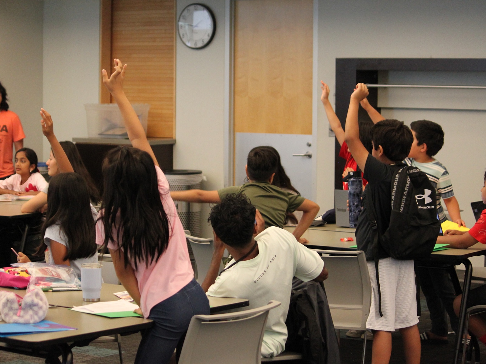 EcoRise camp students raising their hands during a classroom session
