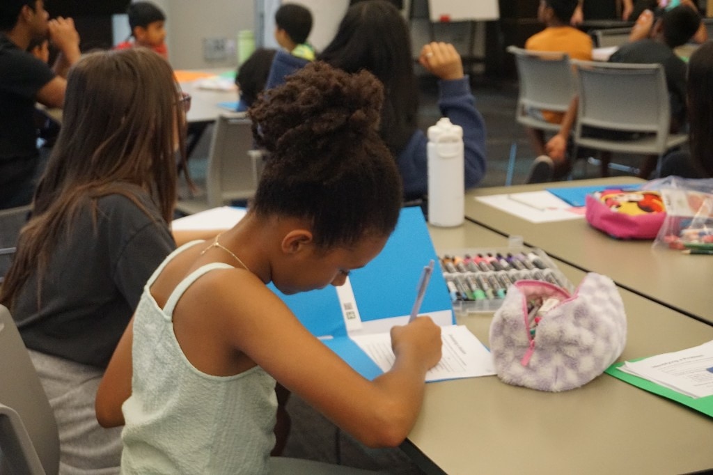 Student writing and refining a Green Dream Showcase presentation at camp